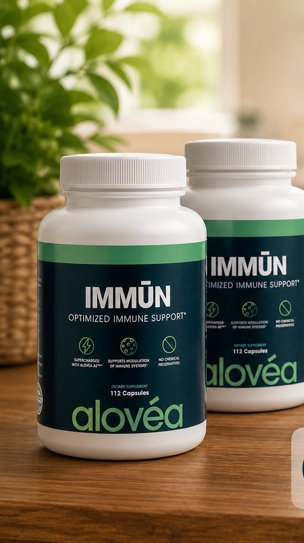 Two bottles of TreoCare Acemannan Immūn on a warm wooden surface with a houseplant in the background — the 90-day 2-bottle supply